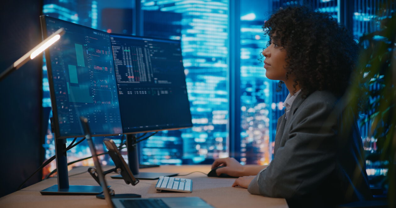 woman works on two computer screens in tech-forward office